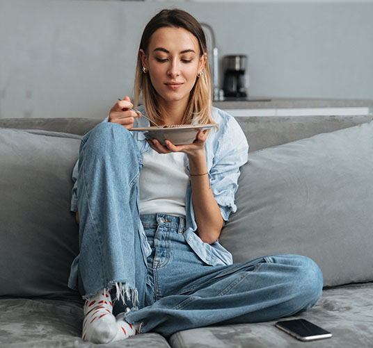 Chica en sofá comiendo